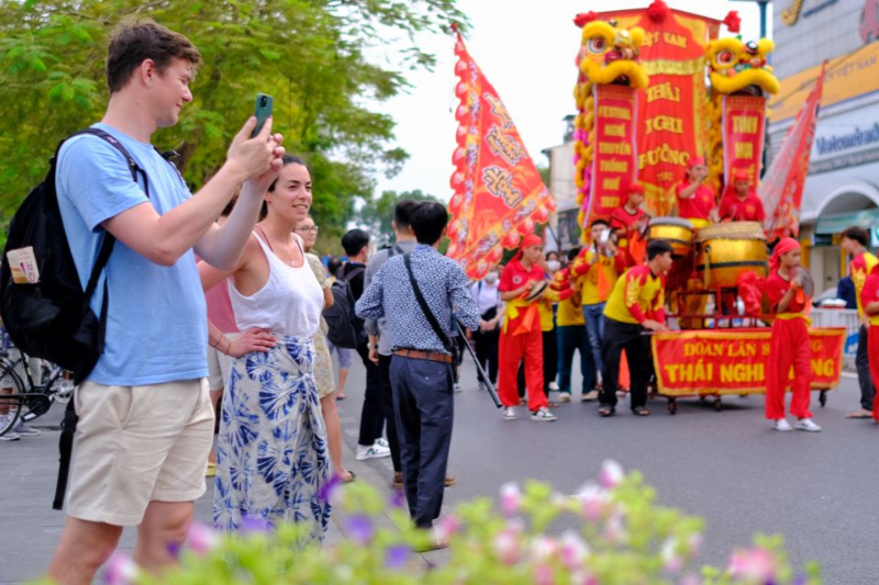 Touristes captivés par les spectacles traditionnels de rue à Hué. (voyage d'entreprise au Vietnam )